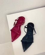 レッドとブラックのストラップサンダルを白い背景の場所に並べたショット。