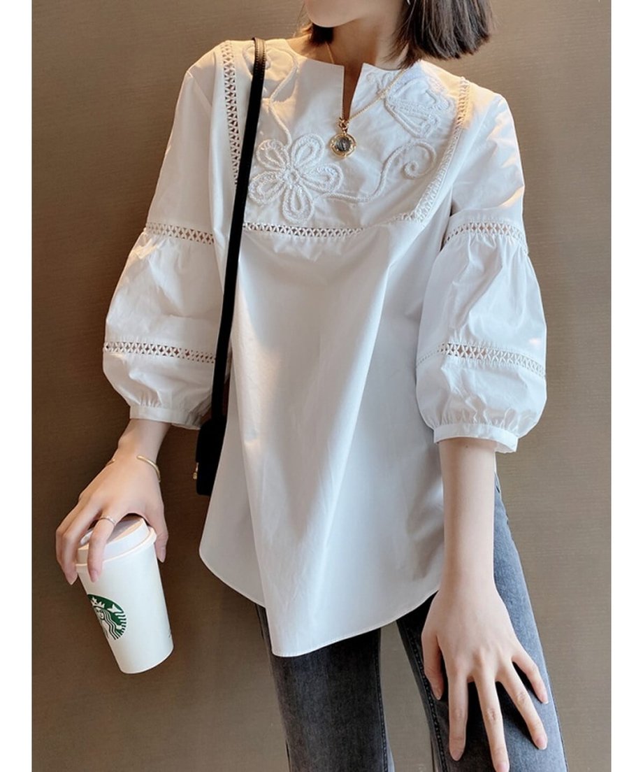 白い刺繍ブラウスとグレーのデニムを合わせた女性の正面カット