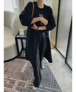 ブラックのフェイクレザーパンツに黒のロングカーディガンとロゴTシャツを合わせた、シックなワントーンスタイル。