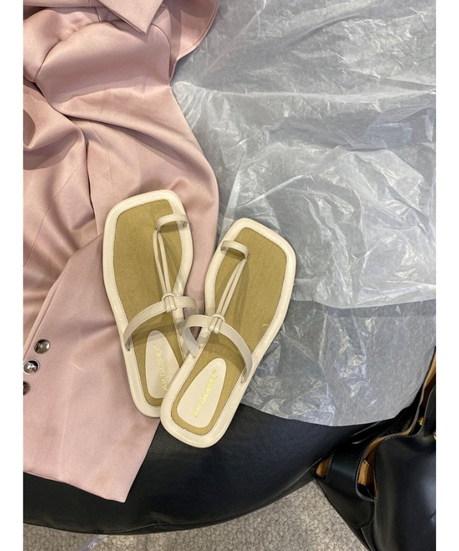 オフホワイトの細ストラップサンダルと、淡いピンクのジャケットを合わせた置き画