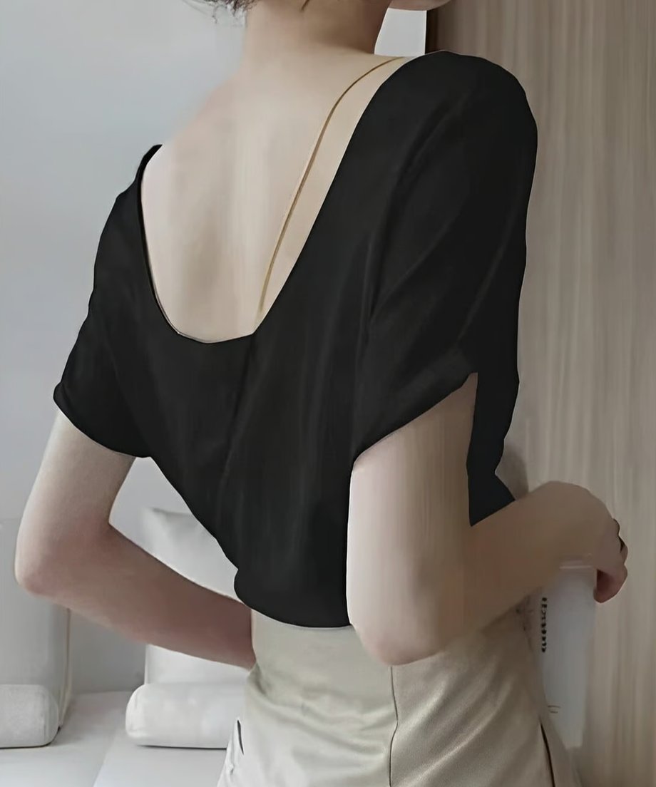 ブラックのバックオープンTシャツを着用した女性のバックスタイル。背中が深くU字に開いたデザインが特徴。