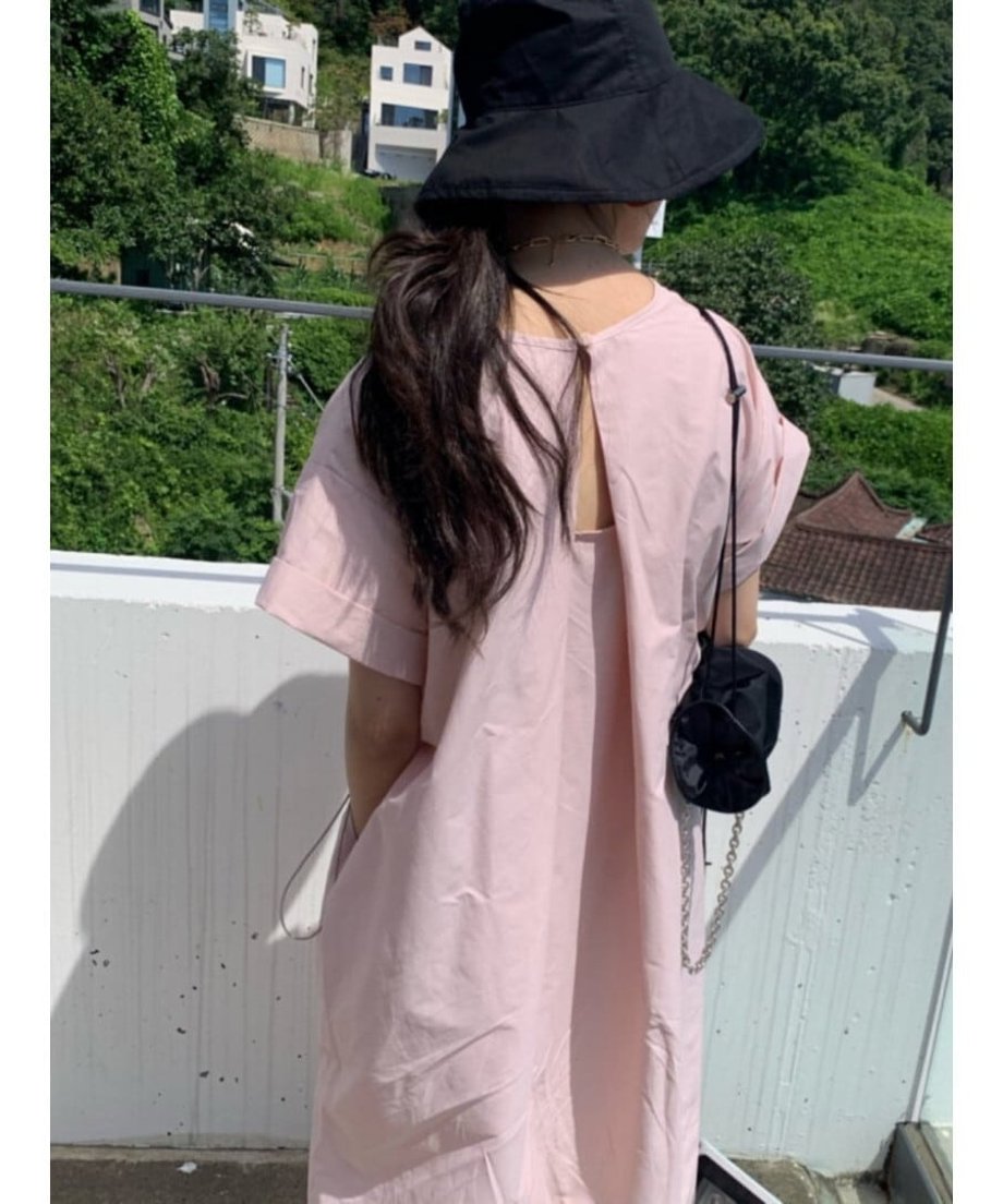 ピンクのワンピースとブラックのバケットハットを合わせた、夏らしいお出かけスタイル。