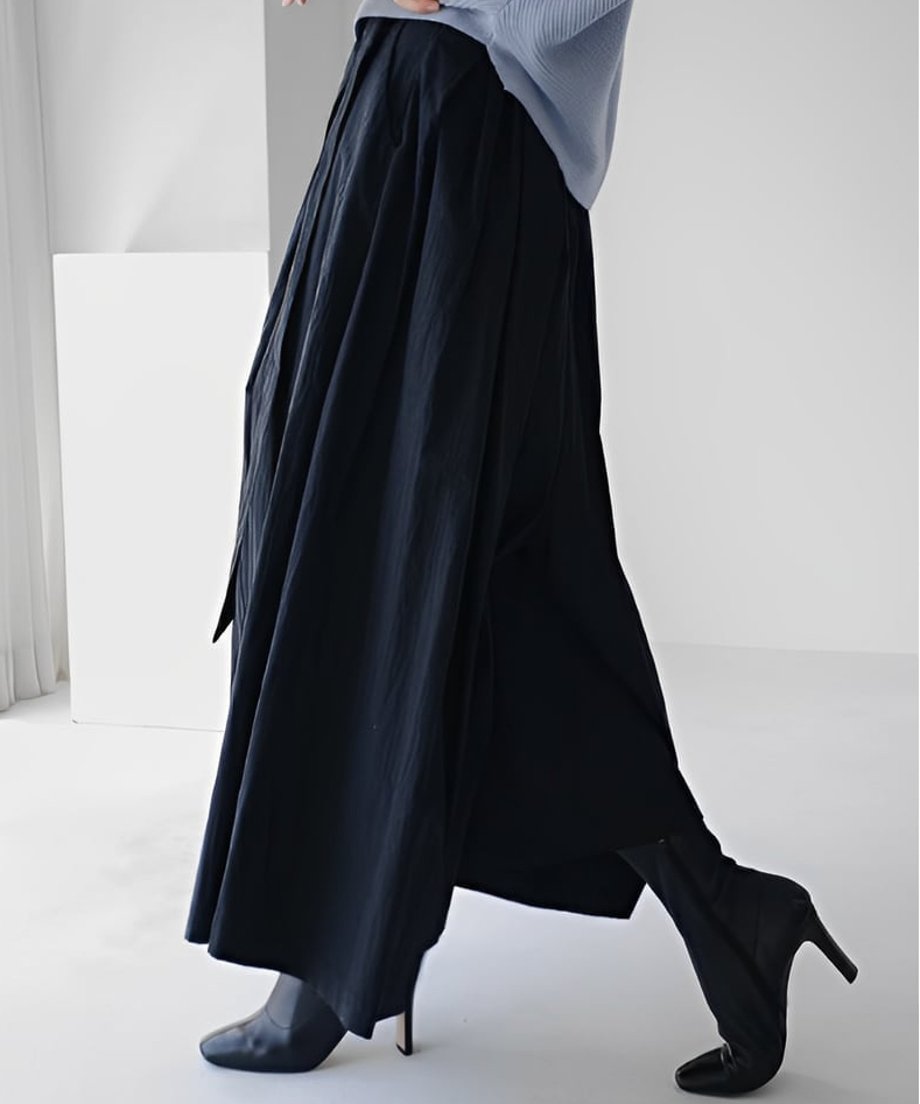 ブラックのワイドパンツを着用して歩く、動きのあるサイドシルエットと生地の質感