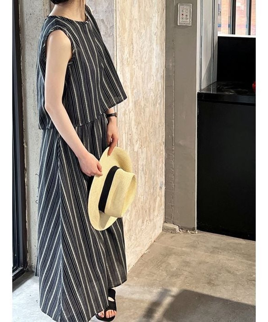 ストライプ柄のノースリーブトップスとロングスカートに、麦わら帽子を合わせた夏らしいコーディネート。