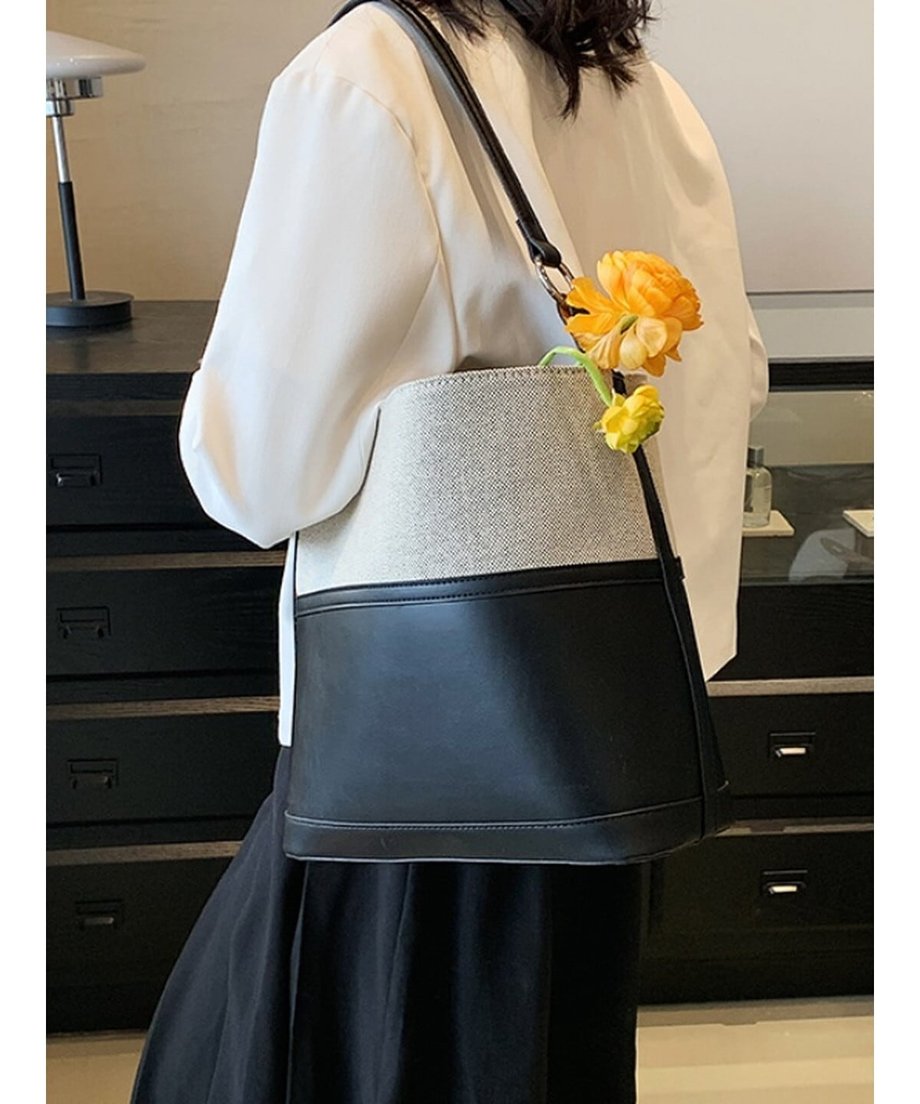 黄色の花をバッグから覗かせた、ブラックのエコレザーバッグのバックスタイル。