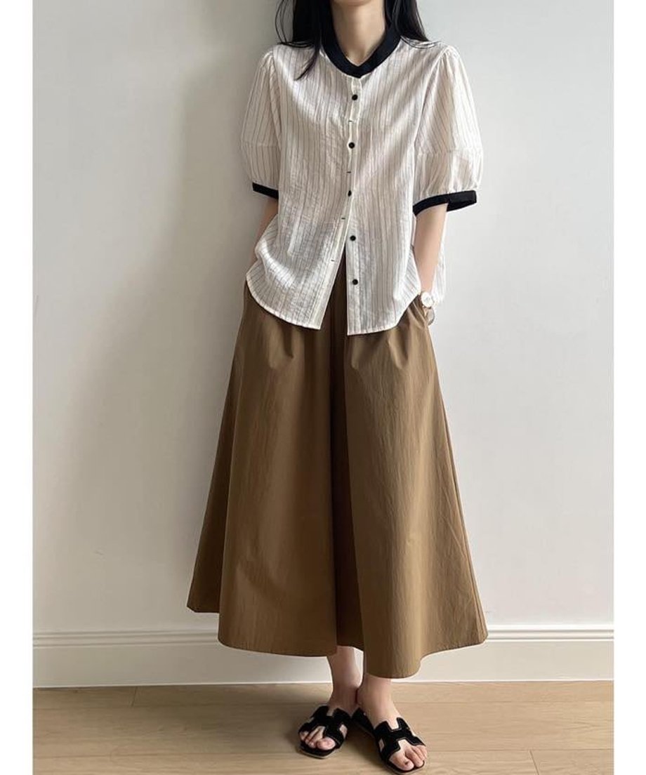 ワイドパンツとサンダルを合わせ、シャツを外に出して着こなしたナチュラルな装い。