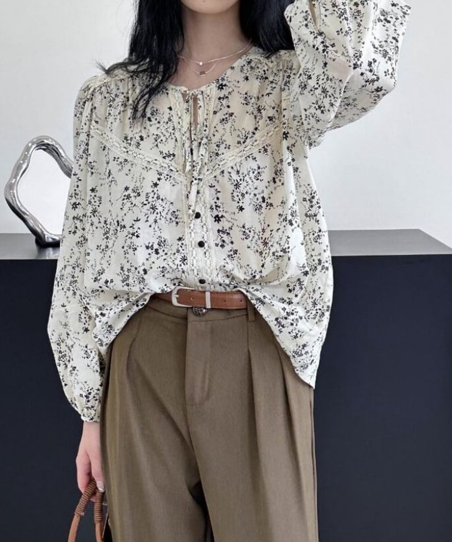 ホワイトの小花柄ブラウスにカーキのタックパンツとブラウンのレザーベルトを合わせた大人のカジュアルコーディネート。
