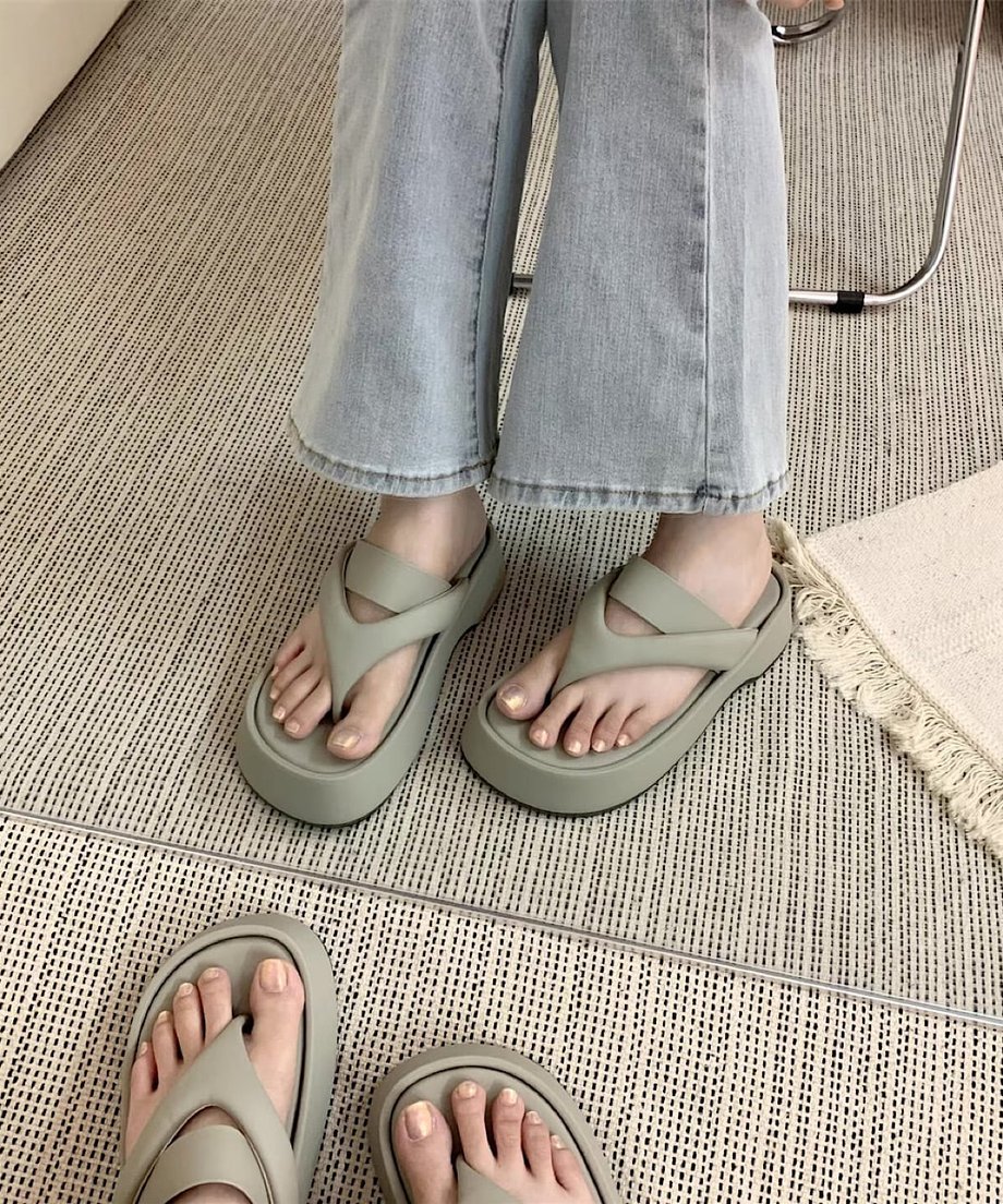 グレーの厚底サンダルをデニムに合わせて着用し、鏡越しに撮影した写真。