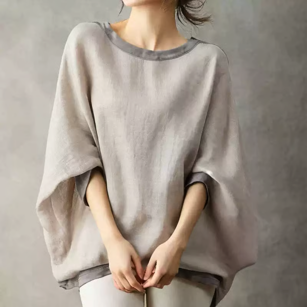 グレージュのプルオーバーを着用した女性、ゆったりとしたシルエットと広めの袖が特徴