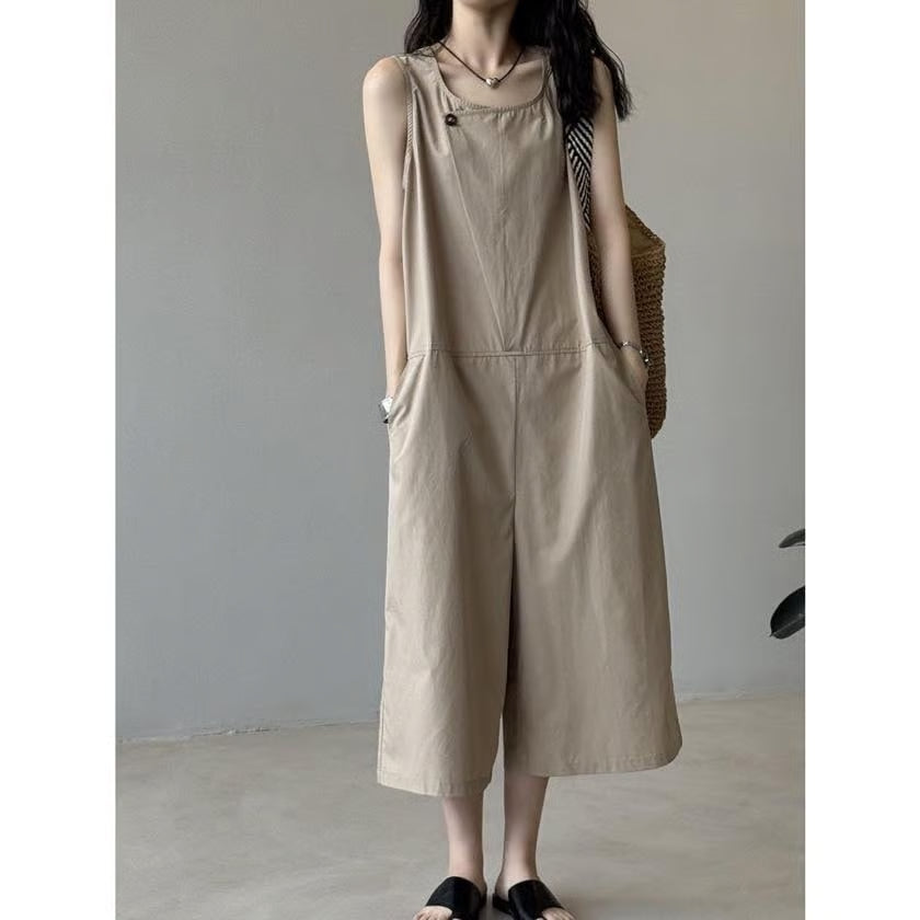 ベージュのオールインワンを着用。リラックスしたポーズで撮影された女性。