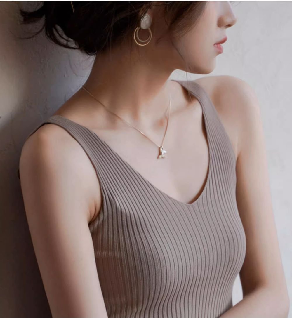 カーキのリブ編みタンクトップを着た女性の側面。シルエットが美しい。