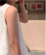 ホワイトのノースリーブトップスを着用した女性の、肩と腕のラインに焦点を当てたクローズアップショット。