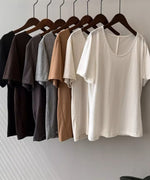 ブラック、ブラウン、ダークグレー、ライトグレー、キャメル、アプリコット、ホワイトのTシャツがハンガーにかけらてて並べられている静物画像。