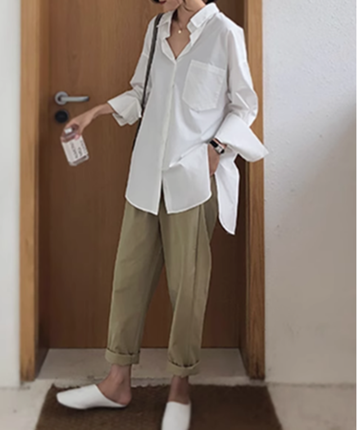 ホワイトシャツとベージュパンツのコーディネートをした女性。